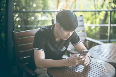 Evinde kanepede otururken Smartphone kullanarak çekici iş adamı. Mobil cihazlar çalışan genç insanlar kavramı. Seçili bir odak portre. Arka plan bulanık. 