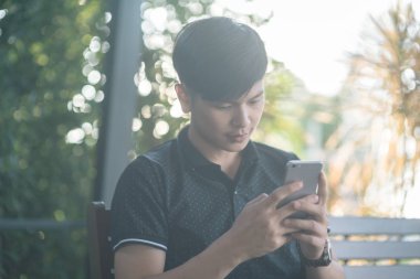 Evinde kanepede otururken Smartphone kullanarak çekici iş adamı. Mobil cihazlar çalışan genç insanlar kavramı. Seçili bir odak portre. Arka plan bulanık. 