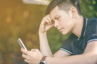 Evinde kanepede otururken Smartphone kullanarak çekici iş adamı. Mobil cihazlar çalışan genç insanlar kavramı. Seçili bir odak portre. Arka plan bulanık. 