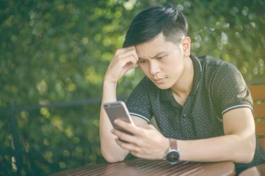 Evinde kanepede otururken Smartphone kullanarak çekici iş adamı. Mobil cihazlar çalışan genç insanlar kavramı. Seçili bir odak portre. Arka plan bulanık. 