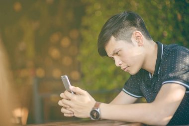 Evinde kanepede otururken Smartphone kullanarak çekici iş adamı. Mobil cihazlar çalışan genç insanlar kavramı. Seçili bir odak portre. Arka plan bulanık. 