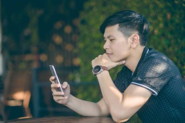 Evinde kanepede otururken Smartphone kullanarak çekici iş adamı. Mobil cihazlar çalışan genç insanlar kavramı. Seçili bir odak portre. Arka plan bulanık. 