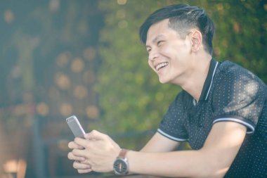 Evinde kanepede otururken Smartphone kullanarak çekici iş adamı. Mobil cihazlar çalışan genç insanlar kavramı. Seçili bir odak portre. Arka plan bulanık. 