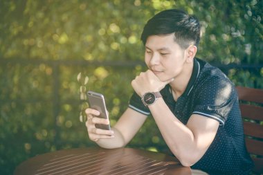 Evinde kanepede otururken Smartphone kullanarak çekici iş adamı. Mobil cihazlar çalışan genç insanlar kavramı. Seçili bir odak portre. Arka plan bulanık. 