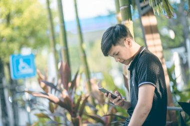 Evinde kanepede otururken Smartphone kullanarak çekici iş adamı. Mobil cihazlar çalışan genç insanlar kavramı. Seçili bir odak portre. Arka plan bulanık. 