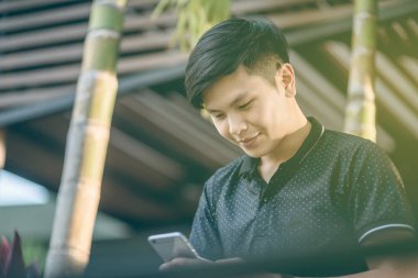 Evinde kanepede otururken Smartphone kullanarak çekici iş adamı. Mobil cihazlar çalışan genç insanlar kavramı. Seçili bir odak portre. Arka plan bulanık. 