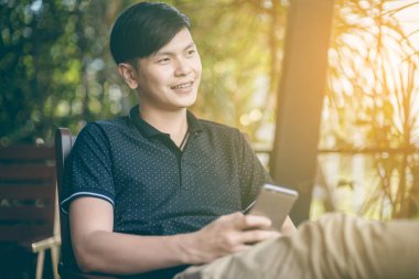 Evinde kanepede otururken Smartphone kullanarak çekici iş adamı. Mobil cihazlar çalışan genç insanlar kavramı. Seçili bir odak portre. Arka plan bulanık. 