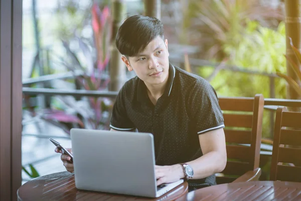 Evinde kanepede otururken Smartphone kullanarak çekici iş adamı. Mobil cihazlar çalışan genç insanlar kavramı. Seçili bir odak portre. Arka plan bulanık. 