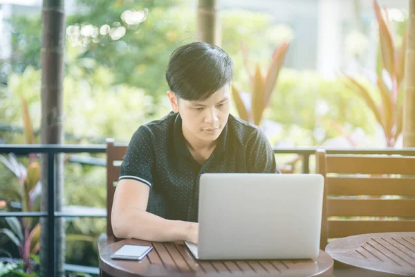 Evinde kanepede otururken Smartphone kullanarak çekici iş adamı. Mobil cihazlar çalışan genç insanlar kavramı. Seçili bir odak portre. Arka plan bulanık. 