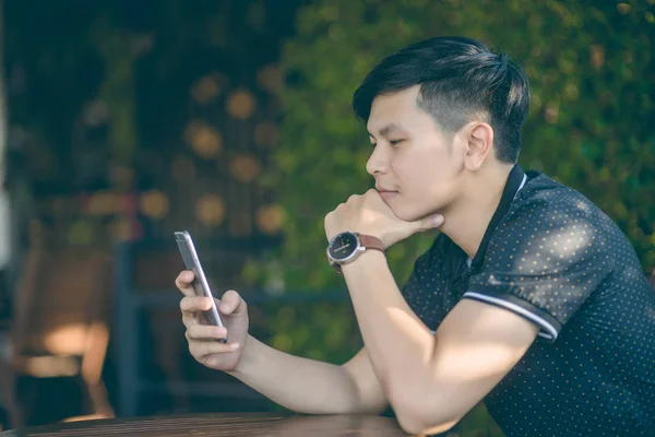 Evinde kanepede otururken Smartphone kullanarak çekici iş adamı. Mobil cihazlar çalışan genç insanlar kavramı. Seçili bir odak portre. Arka plan bulanık. 