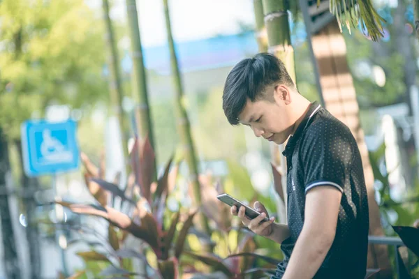 Evinde kanepede otururken Smartphone kullanarak çekici iş adamı. Mobil cihazlar çalışan genç insanlar kavramı. Seçili bir odak portre. Arka plan bulanık. 