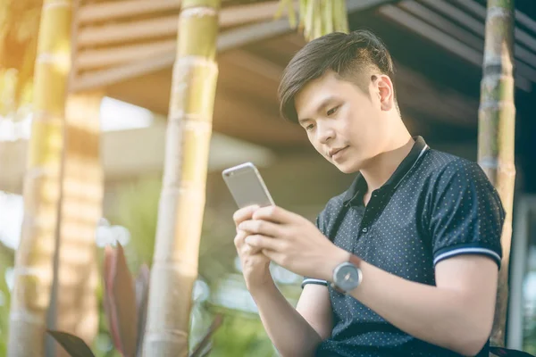 Evinde kanepede otururken Smartphone kullanarak çekici iş adamı. Mobil cihazlar çalışan genç insanlar kavramı. Seçili bir odak portre. Arka plan bulanık. 