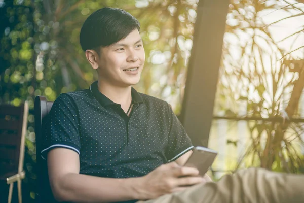 Evinde kanepede otururken Smartphone kullanarak çekici iş adamı. Mobil cihazlar çalışan genç insanlar kavramı. Seçili bir odak portre. Arka plan bulanık. 