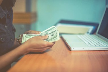 Bir adam elinde, para para biri bizi Doları banknot ve holding nakit elinde veren adam onun elinde tutan işadamı dolar tutar. Para kredi kavramı. Dikey görüntü. Seçici odak