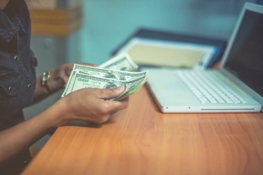 Bir adam elinde, para para biri bizi Doları banknot ve holding nakit elinde veren adam onun elinde tutan işadamı dolar tutar. Para kredi kavramı. Dikey görüntü. Seçici odak