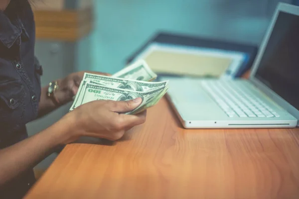 Bir adam elinde, para para biri bizi Doları banknot ve holding nakit elinde veren adam onun elinde tutan işadamı dolar tutar. Para kredi kavramı. Dikey görüntü. Seçici odak