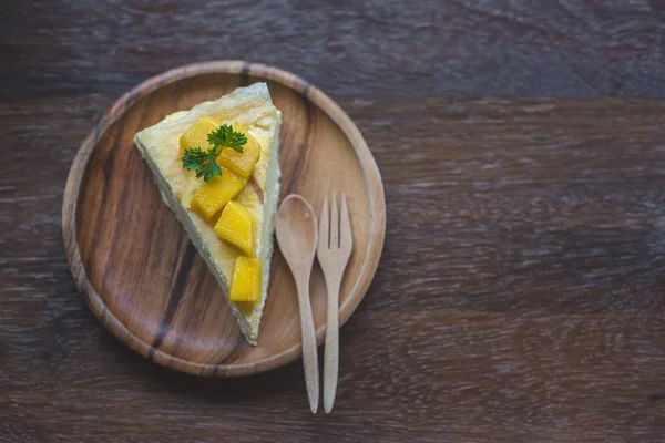 taze mango ile mango krep, kremsi mango mousse kek Beyaz ahşap zemin üzerine kapatın. Tonlama. seçici odak, Mango cheesecake çatal ile beyaz plaka üzerinde