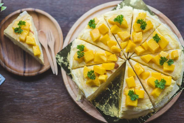 taze mango ile mango krep, kremsi mango mousse kek Beyaz ahşap zemin üzerine kapatın. Tonlama. seçici odak, Mango cheesecake çatal ile beyaz plaka üzerinde