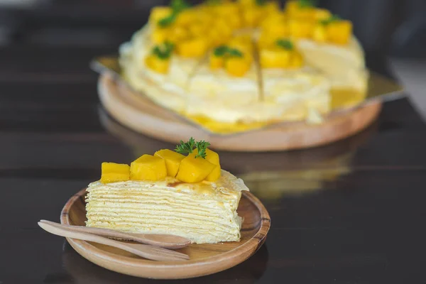 taze mango ile mango krep, kremsi mango mousse kek Beyaz ahşap zemin üzerine kapatın. Tonlama. seçici odak, Mango cheesecake çatal ile beyaz plaka üzerinde