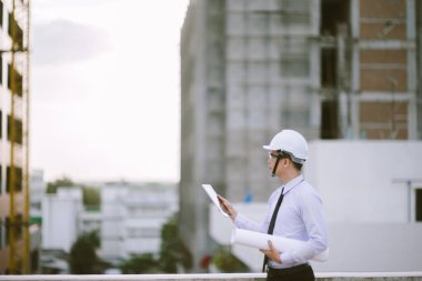 Gülümseyen genç mimar veya Oluşturucusu'nda kask ile mühendislik 