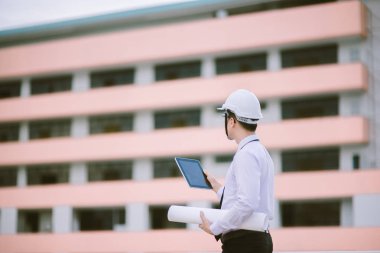Gülümseyen genç mimar veya Oluşturucusu'nda kask ile mühendislik 