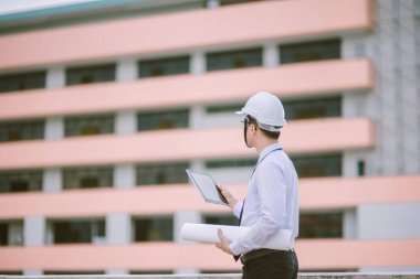 Gülümseyen genç mimar veya Oluşturucusu'nda kask ile mühendislik 