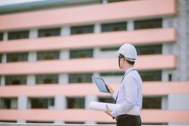 Gülümseyen genç mimar veya Oluşturucusu'nda kask ile mühendislik 