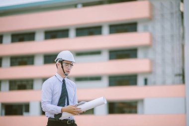Gülümseyen genç mimar veya Oluşturucusu'nda kask ile mühendislik 