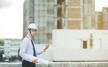 Gülümseyen genç mimar veya Oluşturucusu'nda kask ile mühendislik 