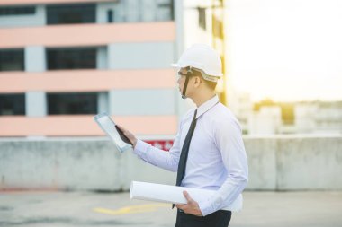 Gülümseyen genç mimar veya Oluşturucusu'nda kask ile mühendislik 