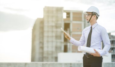 Gülümseyen genç mimar veya Oluşturucusu'nda kask ile mühendislik 