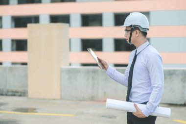 Gülümseyen genç mimar veya Oluşturucusu'nda kask ile mühendislik 