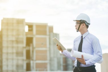 Gülümseyen genç mimar veya Oluşturucusu'nda kask ile mühendislik 