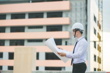 Gülümseyen genç mimar veya Oluşturucusu'nda kask ile mühendislik 