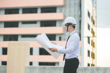 Gülümseyen genç mimar veya Oluşturucusu'nda kask ile mühendislik 