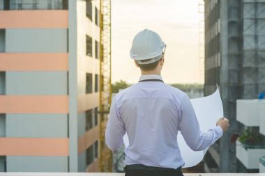 Gülümseyen genç mimar veya Oluşturucusu'nda kask ile mühendislik 