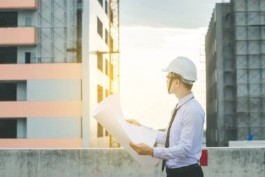 Gülümseyen genç mimar veya Oluşturucusu'nda kask ile mühendislik 