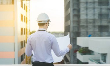 Gülümseyen genç mimar veya Oluşturucusu'nda kask ile mühendislik 