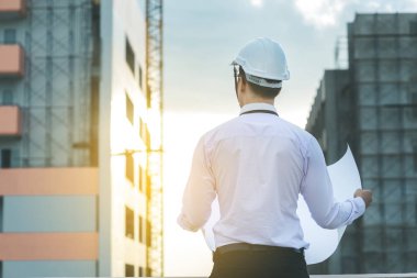 Gülümseyen genç mimar veya Oluşturucusu'nda kask ile mühendislik 