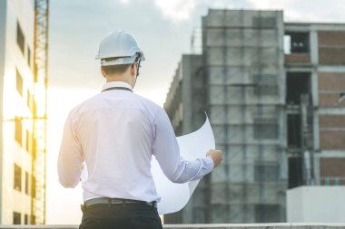 Gülümseyen genç mimar veya Oluşturucusu'nda kask ile mühendislik 