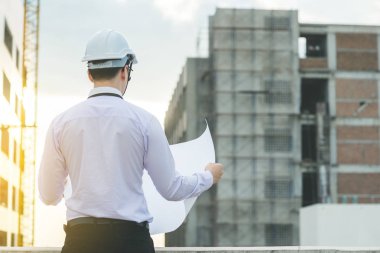 Gülümseyen genç mimar veya Oluşturucusu'nda kask ile mühendislik 