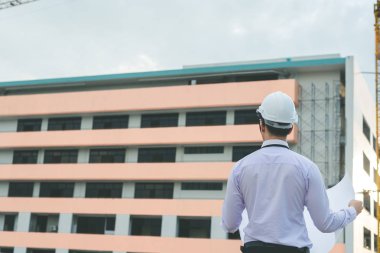 Gülümseyen genç mimar veya Oluşturucusu'nda kask ile mühendislik 