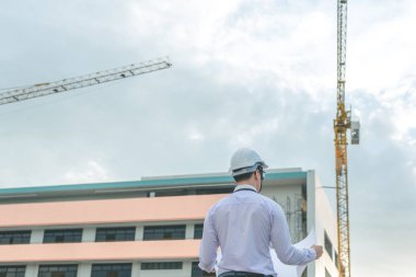 Gülümseyen genç mimar veya Oluşturucusu'nda kask ile mühendislik 