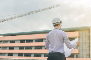 Gülümseyen genç mimar veya Oluşturucusu'nda kask ile mühendislik 