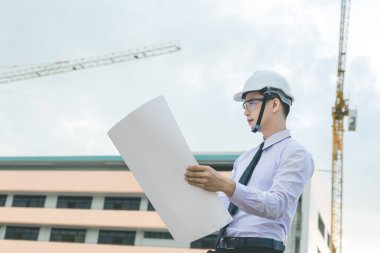 Gülümseyen genç mimar veya Oluşturucusu'nda kask ile mühendislik 