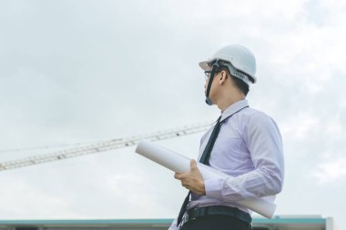 Gülümseyen genç mimar veya Oluşturucusu'nda kask ile mühendislik 