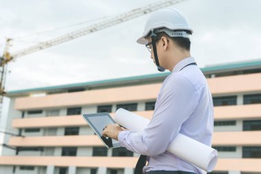 Gülümseyen genç mimar veya Oluşturucusu'nda kask ile mühendislik 