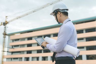 Gülümseyen genç mimar veya Oluşturucusu'nda kask ile mühendislik 