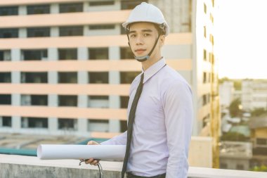 Gülümseyen genç mimar veya Oluşturucusu'nda kask ile mühendislik 