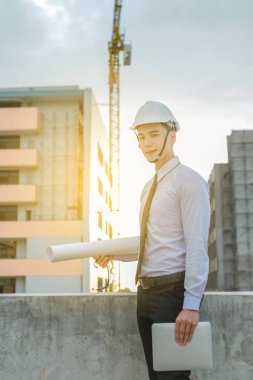 Gülümseyen genç mimar veya Oluşturucusu'nda kask ile mühendislik 